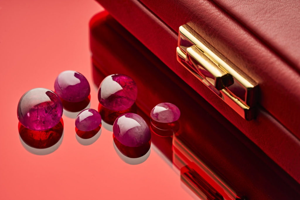 Several rubies next to a briefcase