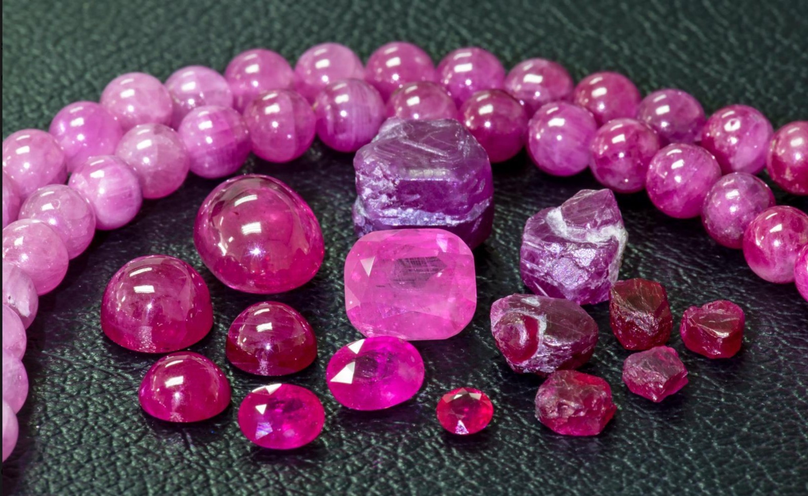 Scattered rubies in front of a ruby necklace