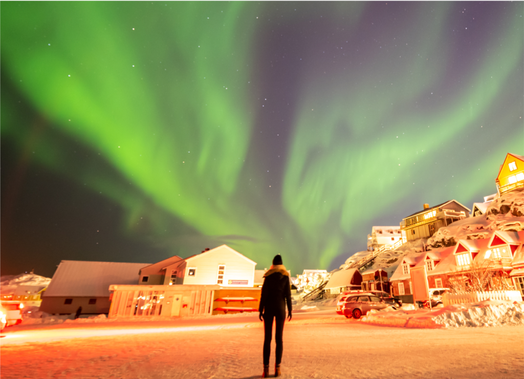 A person standing under the Northern Lights