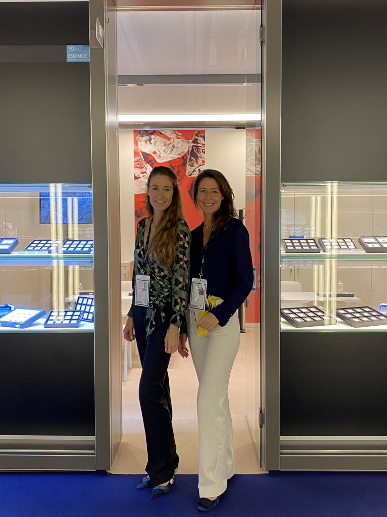 Two women working in a jewelry shop and smiling, standing together