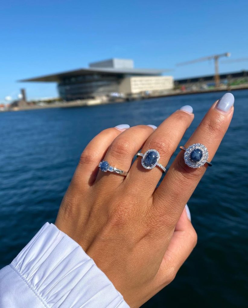 A woman wearing sapphire rings on her fingers