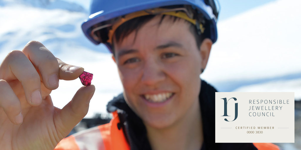 Woman in hard hat holding an uncut ruby between her thumb and index finger in the foreground with the Responsible Jewellery Council logo and Certified Member Number 0000 3830